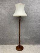 An early 20th century turned and fluted mahogany standard lamp with shade. H.182cm