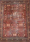 A large Shirvan carpet with stylised flowerhead motifs across the burgundy field within multiple