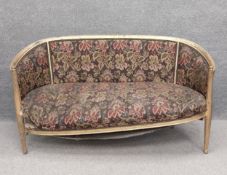 A Louis XVI style giltwood framed salon sofa with needlework upholstery on tapering fluted supports.