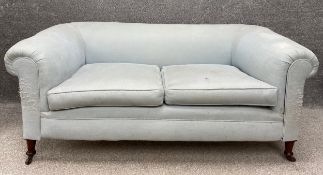 A 19th century two seater sofa upholstered in duck egg calico with scrolled armrests and back on