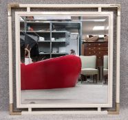 A 1970's vintage wall mirror having a square bevelled plate inset into a painted steel square