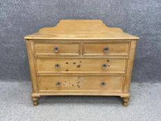 A late 19th century pine chest of drawers having a raised and shaped gallery back above two short