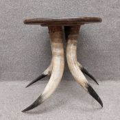 A mid-century oak circular occasional table on four twisted and splayed horn supports of natural