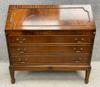 A Georgian style mahogany bureau on stand with a fall front opening on to a fitted interior with a