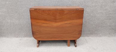 A 1950's walnut drop flap dining table in the Art Deco style. H.75 W.91 D.40cm extends to W.152cm