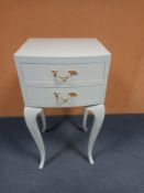 A contemporary painted bow fronted bedside tabe with two drawers on cabriole supports. H. 67cm W.