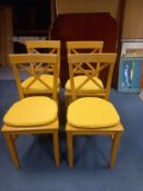 A set of four 1970's vintage beech dining chairs with original squab cushions.