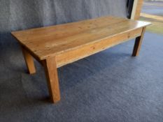 A large Victorian farmhouse style pine coffee table with a plank top over a single drawer on