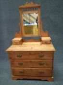 A Victorian pine dressing chest having a shaped swing mirror above a superstructure with two