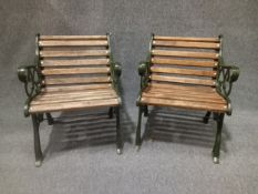 A pair of contemporary painted cast iron garden armchairs in the 19th century style with scrolling