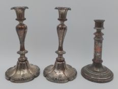 A pair of silver plated candlesticks along with a single candlestick. H.27cm (largest)