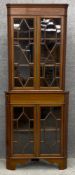 An Edwardian mahogany floor standing corner cabinet with ebony and satinwood inlay, in two parts.