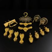 A collection of brass and gilt metal fixings to include four cup and cover handles, a swing