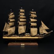 A 20th century handmade model of the three mast clipper ship 'The Cutty Sark' on a faux leather