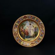 A Royal Vienna hand painted and gilt porcelain plate with a classical scene of the three graces