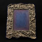 A hallmarked Irish silver picture frame with a beaded inner border surrounded by cherubs and