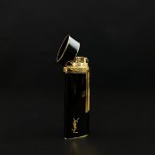 A vintage Yves Saint Laurent gilt and black lacquered Colibri cigarette lighter with maker's marks