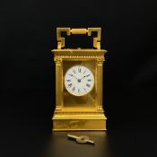 A 20th century brass carriage clock with a shaped swing handle over a moulded cornice with a dial