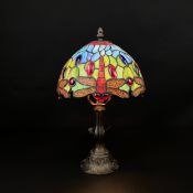 A Tiffany style Dragonfly lamp with a leaded glass shade in colours on a cast Art Nouveau style