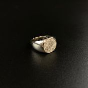 A hallmarked 9ct white gold signet ring with an oval face inset with cubic zirconia stones. Weight: