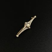 An Art Deco yellow and white metal bar brooch inset with a central pearl flanked by four rows of