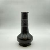 An archaistic Chinese bronze bottle vase with a tall narrow stem having a collar decorated with