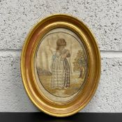 A Georgian silk embroidery of a young girl and a cat with hand painted hair, face and arms in a