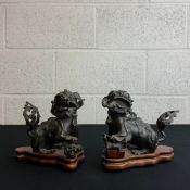 A pair of 19th century Chinese bronze foo dogs or temple lions on shaped hardwood bases. H.16cm