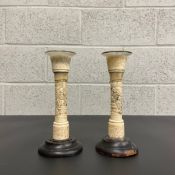 A pair of early 20th century Chinese import bone candlesticks with glass holders carved with
