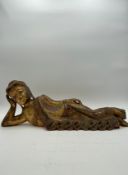 A 20th century hand carved and painted giltwood reclining Buddha decorated with applied glass beads.