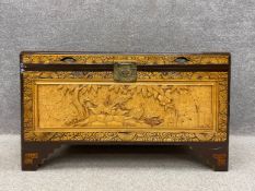 A 20th century Chinese camphor chest or coffer profusely carved with birds and foliage and raised on