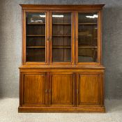 A large 19th century walnut library bookcase in three parts having a moulded cornice above three