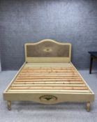 A 20th century French style painted bed frame having a shaped rattan headboard with a sunburst