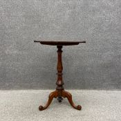 A Georgian walnut occasional table having a square top over a turned stem on outswept scrolling