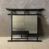 A contemporary Oriental wall hanging mirror with a curved and openwork ebonised lacquered frame