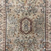 A Persian silk Kashan rug having a central lozenge medallion surrounded by trees in midnight and