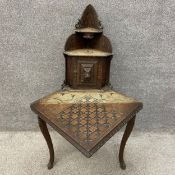 A late 19th century oak corner table having a shaped and stepped waterfall superstructure of two