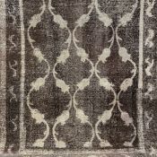 An Iranian Baluch woollen carpet with allover scrolling patterns over a mushroom ground with a