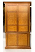 A large contemporary walnut and birdseye maple TV/media unit in two parts having a moulded cornice