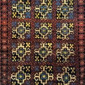 A Balouch woollen rug with all-over geometric designs in mustard and sapphire blue with iron red
