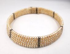 A choker necklace with three rows of fresh water pearls on a sprung armature with seven equally