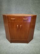 A mid century G-Plan E Gomme teak corner cabinet having a single frieze secretaire drawer with a