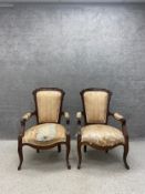 A pair of late 19th/early 20th century French style walnut armchairs each having a carved
