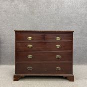 A Georgian mahogany chest of two short over three long graduating drawers on shaped bracket