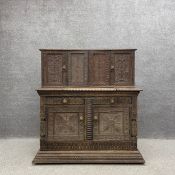 A 17th century oak court cupboard with four panelled cabinet doors opening on to a fitted Gothic