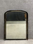 A late 19th century overmantel mirror having an ebonised frame with an arched top decorated with