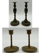 A pair of early 20th century patinated brass Art Deco candlesticks of turned and faceted baluster