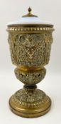 A large Neoclassical brass urn with with a thick brass mounted opalescent glass lid over a
