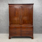 A 19th century mahogany linen press having a moulded cornice above two crossbanded and satinwood