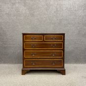 A Georgian style mahogany chest of drawers having a paterae inlaid and crossbanded top over two